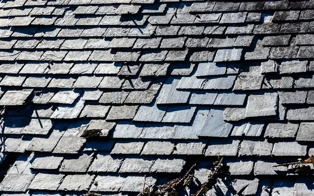 Pizarras rotas y desplazadas en un tejado antiguo